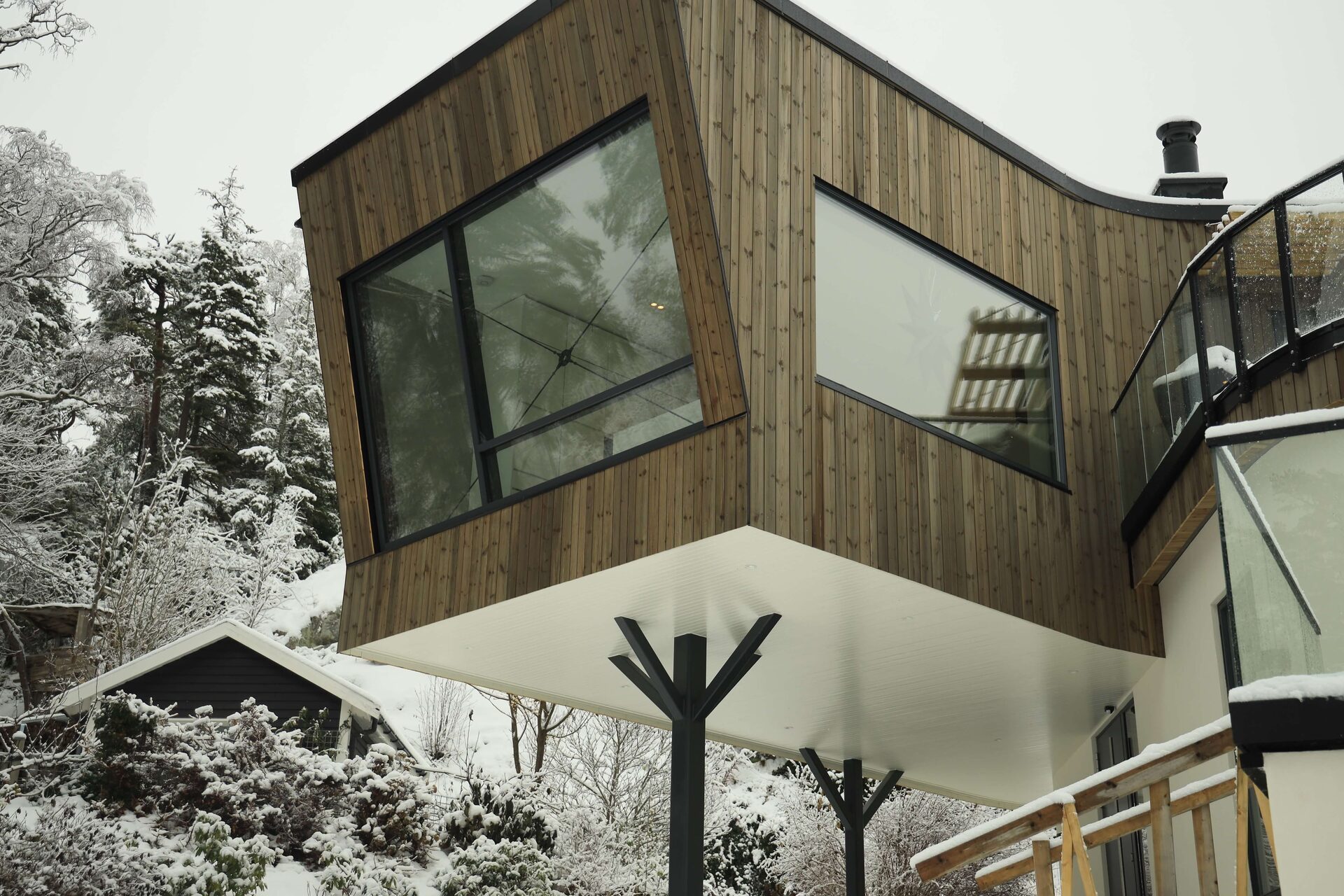 Complexe houten woning met overkragingen en metalen steun